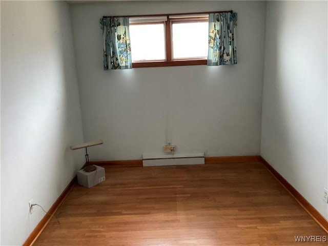 unfurnished room featuring light wood-style floors, baseboards, and baseboard heating