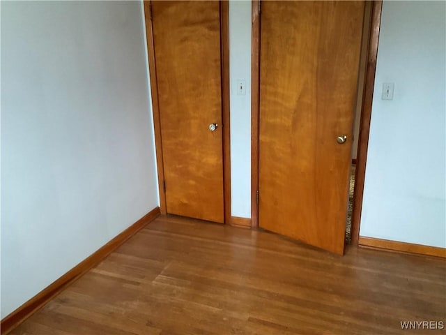 unfurnished bedroom featuring baseboards and wood finished floors