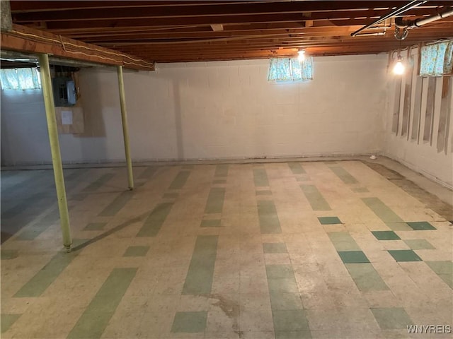 basement featuring electric panel and tile patterned floors