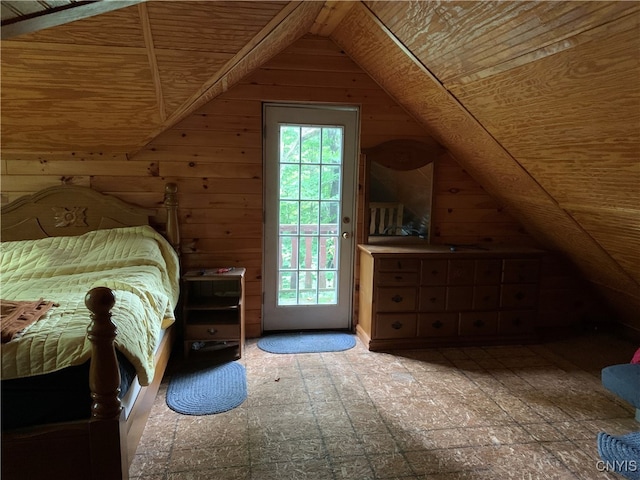 unfurnished bedroom with wood walls, access to outside, and vaulted ceiling