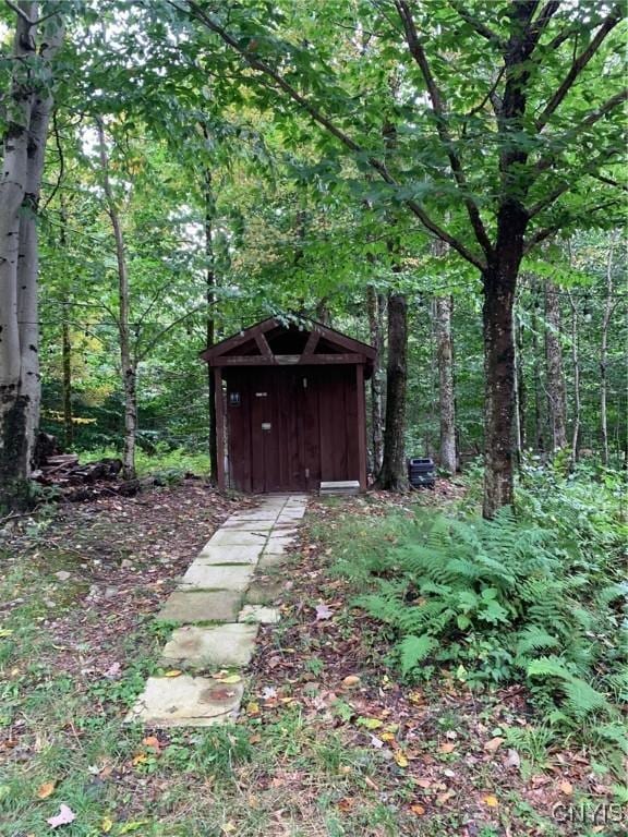 view of shed with a wooded view