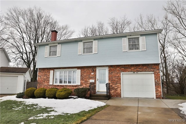 colonial inspired home featuring a garage, a chimney, concrete driveway, and brick siding