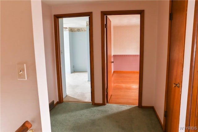 hall featuring carpet flooring and baseboards