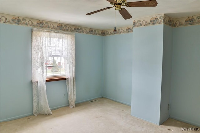 empty room with ceiling fan, visible vents, and baseboards