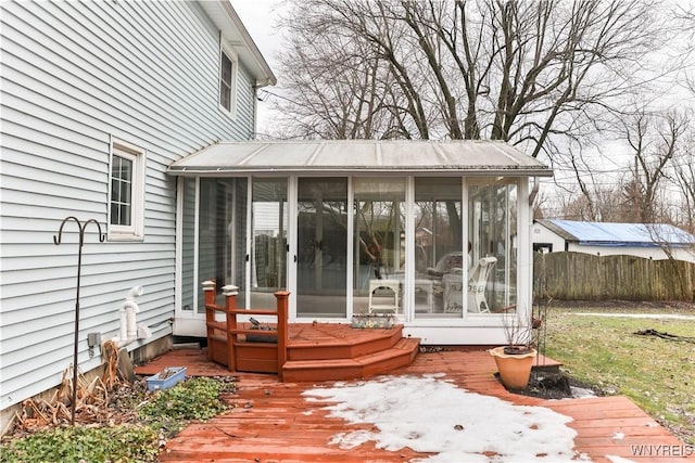 wooden terrace with a sunroom and fence