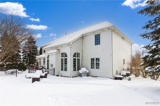 snow covered property with fence