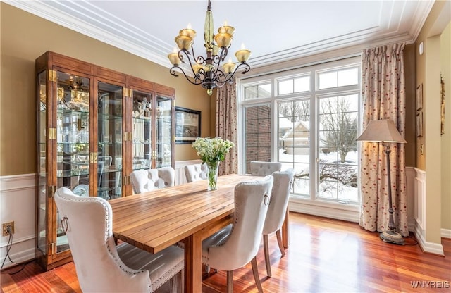 dining space featuring a chandelier, crown molding, and wood finished floors