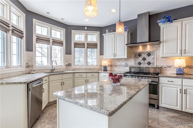 kitchen featuring white cabinets, wall chimney exhaust hood, appliances with stainless steel finishes, light stone countertops, and a sink