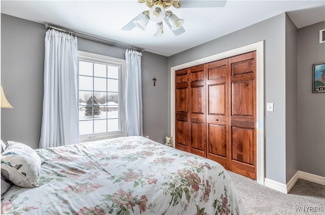 carpeted bedroom with ceiling fan, a closet, and baseboards