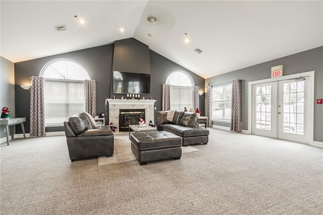 carpeted living room with visible vents, baseboards, a premium fireplace, french doors, and high vaulted ceiling