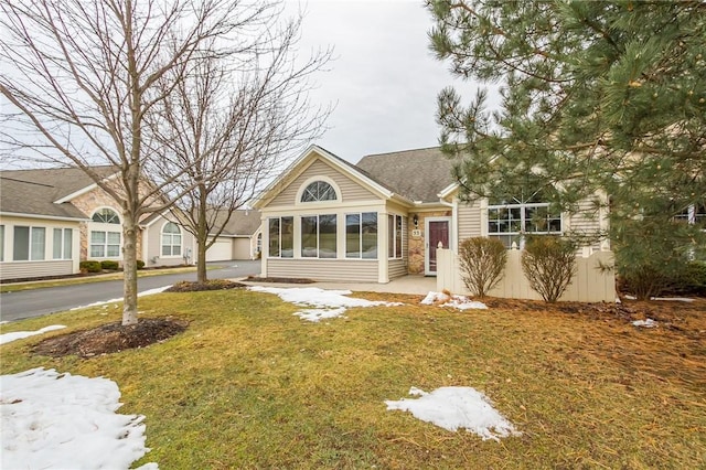 view of front of house featuring aphalt driveway, a garage, and a front lawn