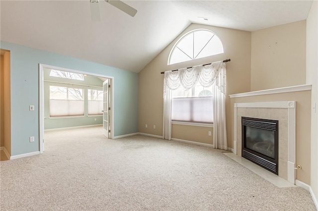 unfurnished living room with a wealth of natural light, carpet flooring, and a tiled fireplace