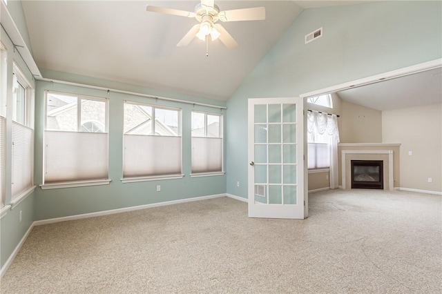 unfurnished living room featuring visible vents, baseboards, a ceiling fan, a glass covered fireplace, and carpet