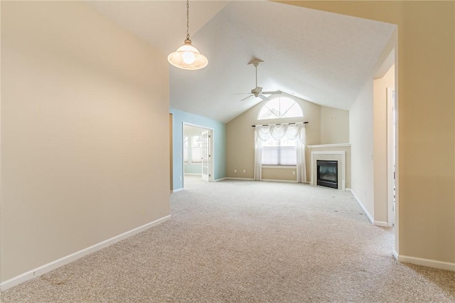 unfurnished living room with lofted ceiling, light colored carpet, a ceiling fan, a glass covered fireplace, and baseboards