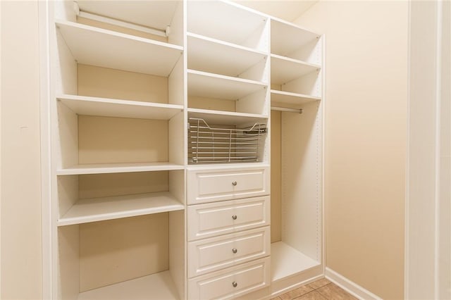 walk in closet with light tile patterned floors