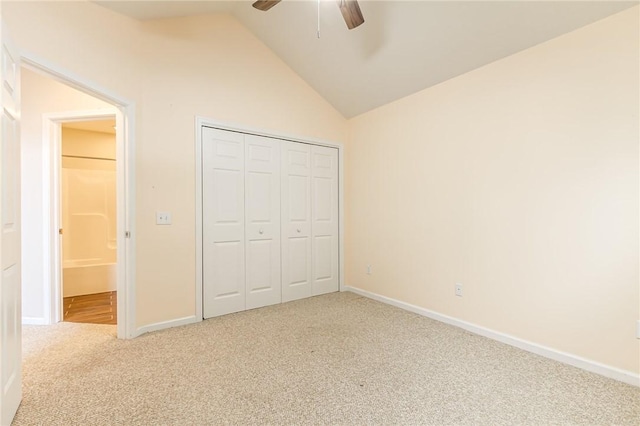 unfurnished bedroom featuring lofted ceiling, a closet, baseboards, and carpet flooring