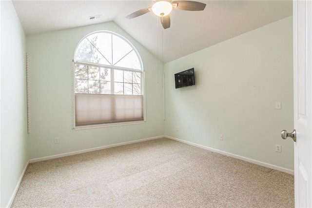 empty room featuring visible vents, baseboards, ceiling fan, carpet, and vaulted ceiling