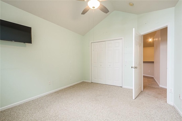 unfurnished bedroom with a closet, light carpet, vaulted ceiling, ceiling fan, and baseboards