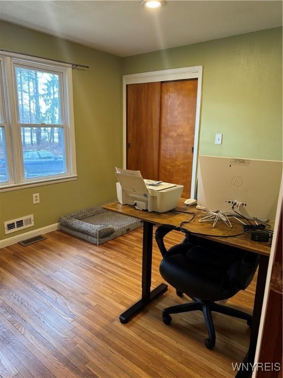 home office featuring baseboards, visible vents, and wood finished floors