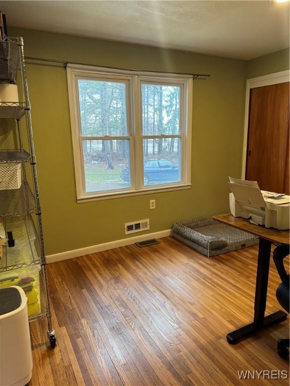 interior space with visible vents, baseboards, and wood finished floors