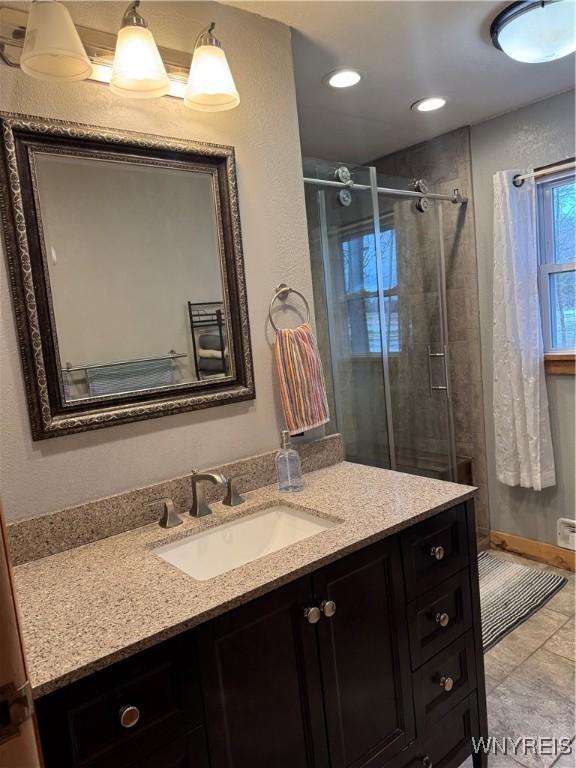 bathroom with recessed lighting, a shower stall, and vanity