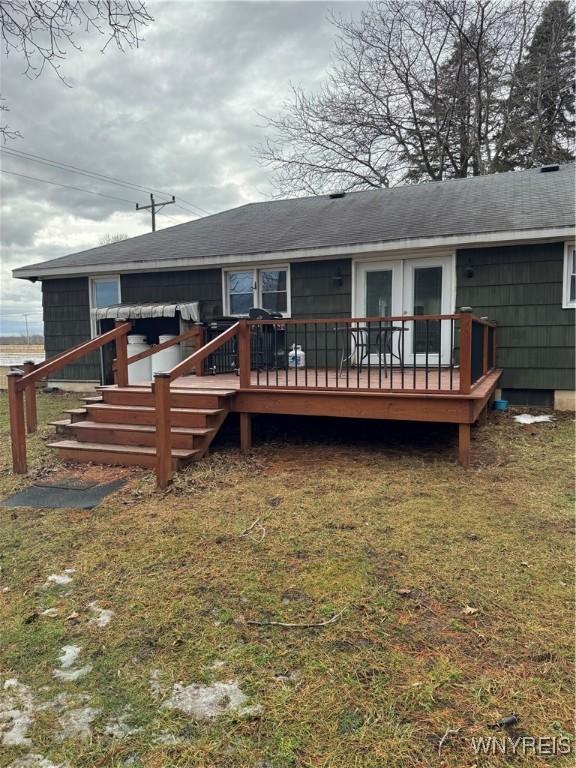 back of house with a shingled roof and a deck