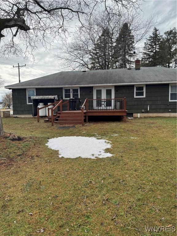 back of house with a yard, a chimney, and a wooden deck