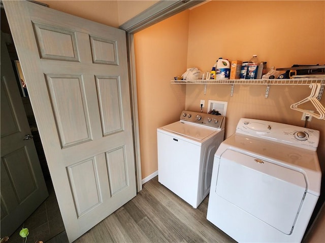 laundry room featuring light wood-type flooring, laundry area, and washer and clothes dryer