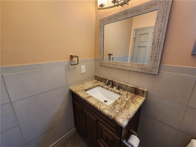 bathroom featuring wainscoting, vanity, and tile walls