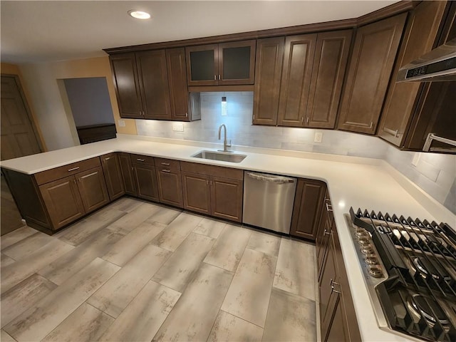 kitchen featuring light countertops, dishwasher, backsplash, and a sink