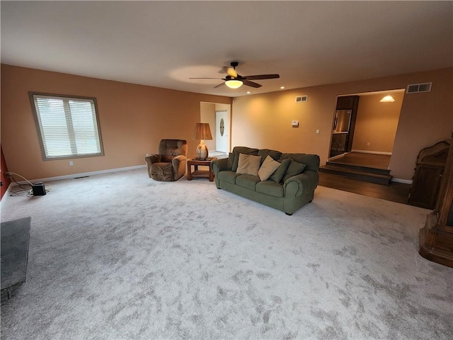 carpeted living area featuring baseboards, visible vents, and a ceiling fan