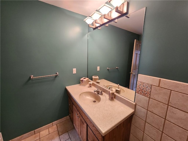 bathroom featuring stone tile flooring, vanity, and baseboards