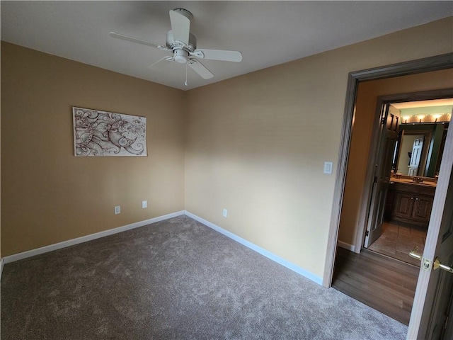 unfurnished bedroom featuring carpet, baseboards, ceiling fan, and connected bathroom