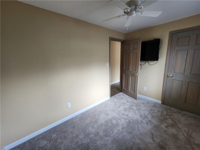 unfurnished bedroom with ceiling fan, carpet floors, and baseboards