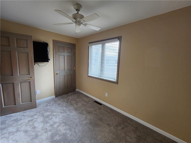 unfurnished bedroom with carpet floors, visible vents, baseboards, and a ceiling fan