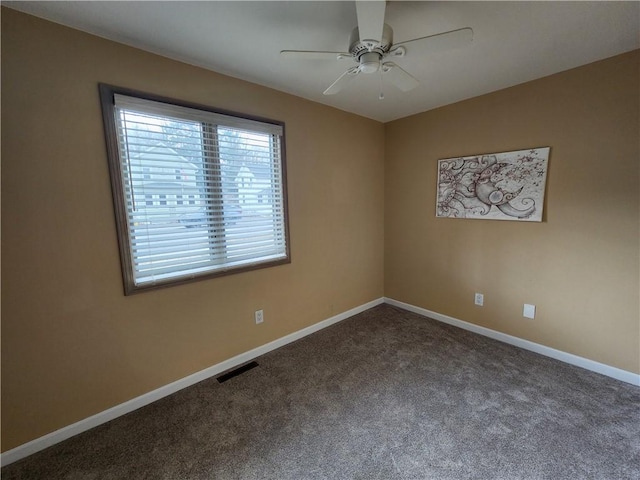 carpeted spare room with ceiling fan, visible vents, and baseboards