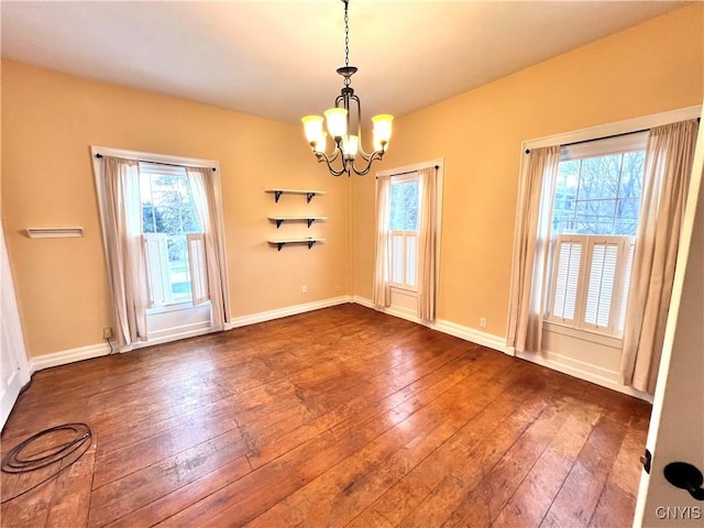 interior space featuring an inviting chandelier, wood-type flooring, and baseboards