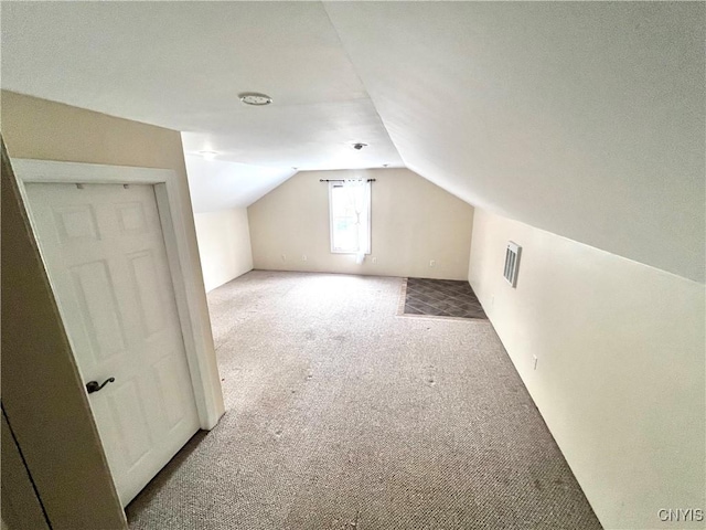 additional living space with lofted ceiling, carpet flooring, and visible vents