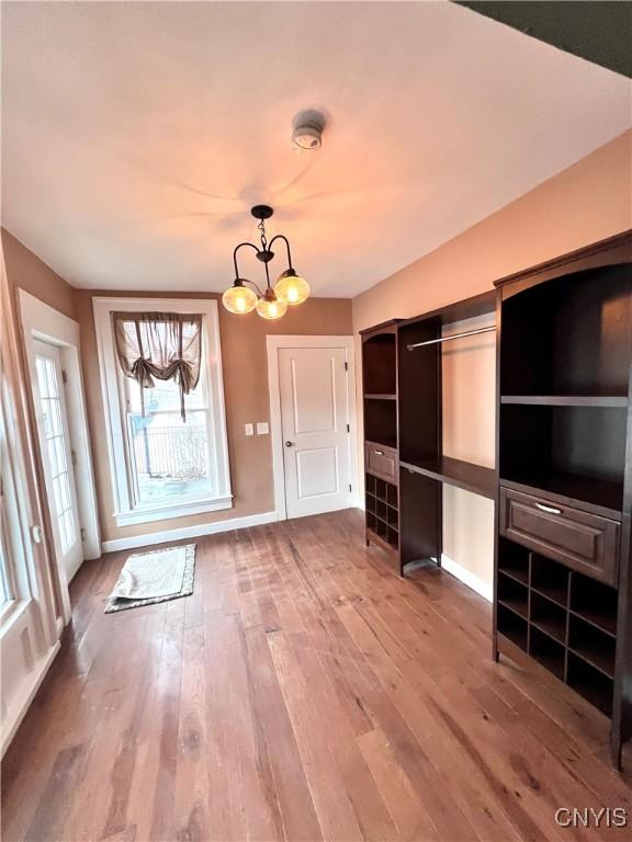 interior space featuring hardwood / wood-style flooring, baseboards, and a chandelier