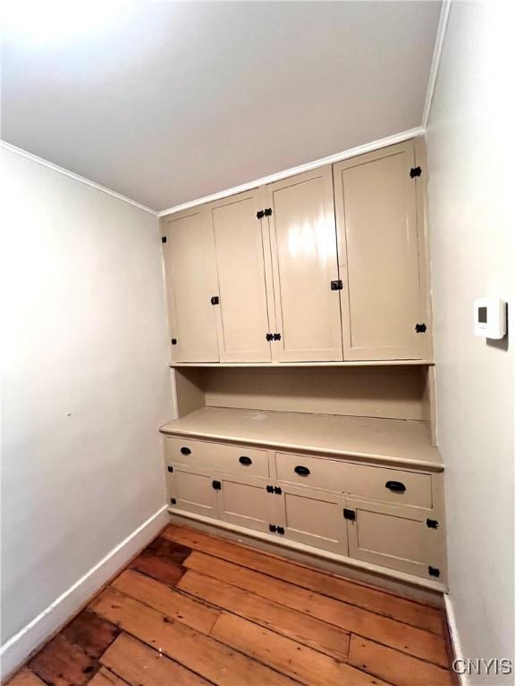 interior space with light wood finished floors, baseboards, and crown molding