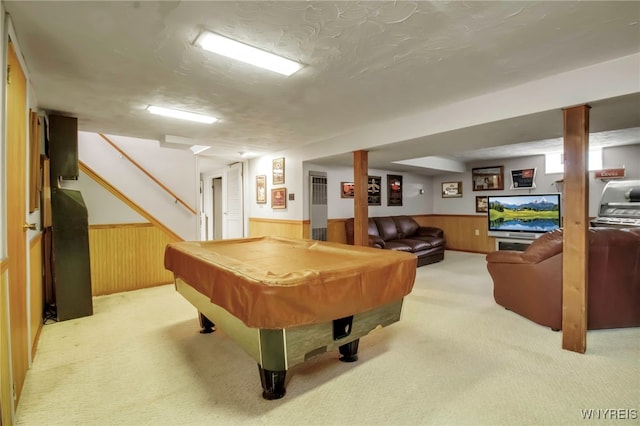 playroom featuring light carpet, wood walls, and wainscoting