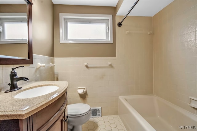 bathroom with tile patterned flooring, visible vents, tile walls, and toilet