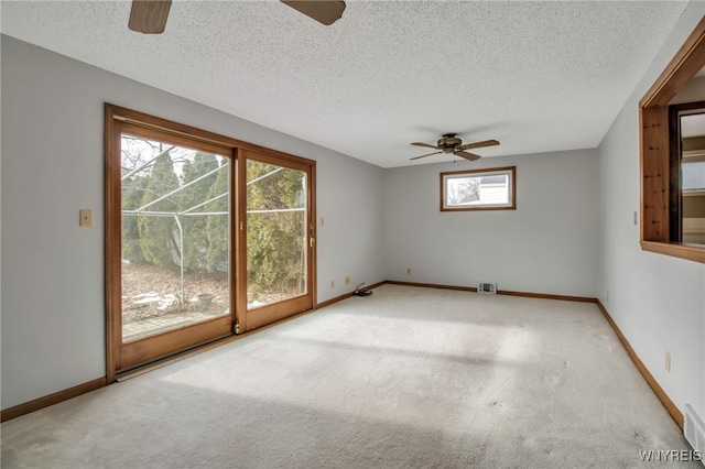 carpeted spare room with a textured ceiling and baseboards