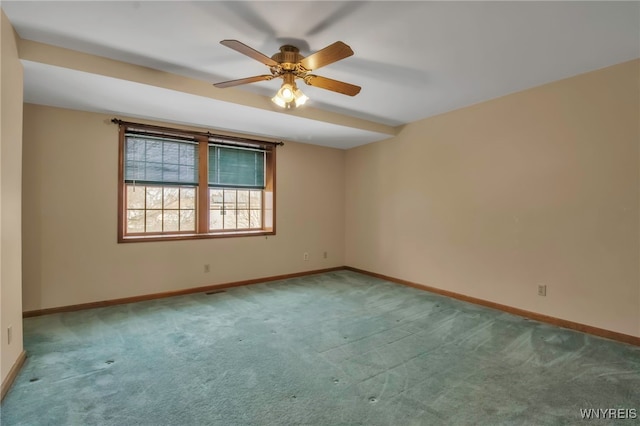 carpeted spare room with ceiling fan and baseboards