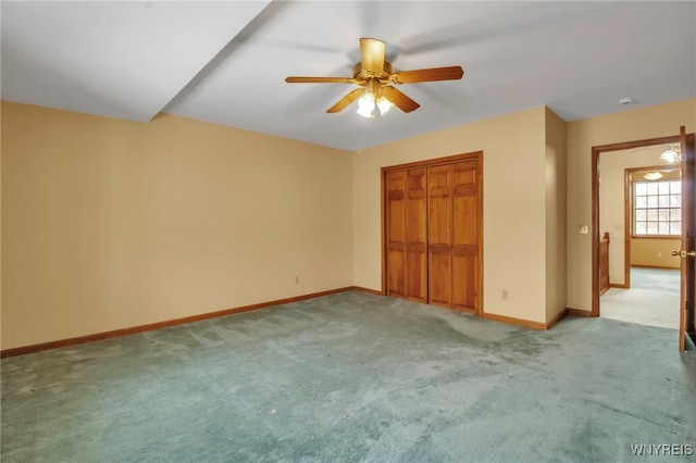 unfurnished bedroom with ceiling fan, baseboards, a closet, and light colored carpet