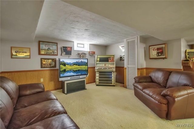 carpeted living room featuring wainscoting and wooden walls