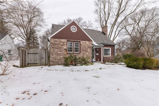 bungalow-style home with a gate and a chimney