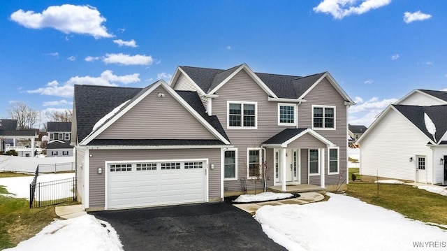 view of front of house featuring a garage, roof with shingles, driveway, and fence