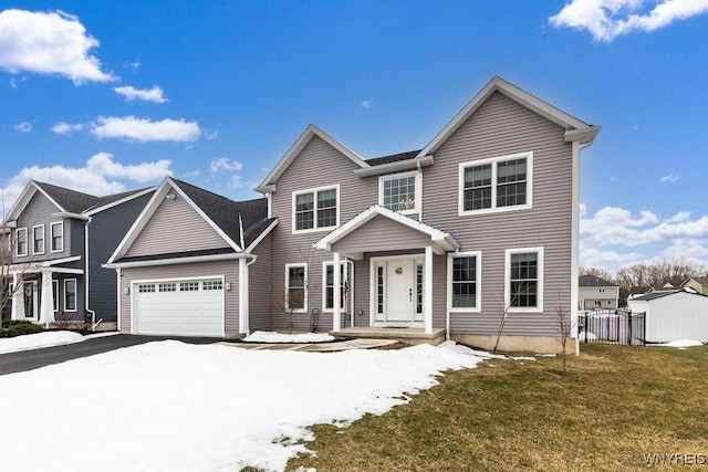 view of front of property with a yard, driveway, an attached garage, and fence