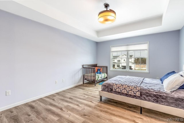 12 Kevwood Ln, Lancaster, NY 14086 - bedroom with baseboards, a raised ceiling, and wood finished floors